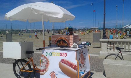 Carmine Napolitano con il suo triciclo allestito per Pizzae Hot Dog sulla spiaggia\\n\\n11/12/2015 01.13